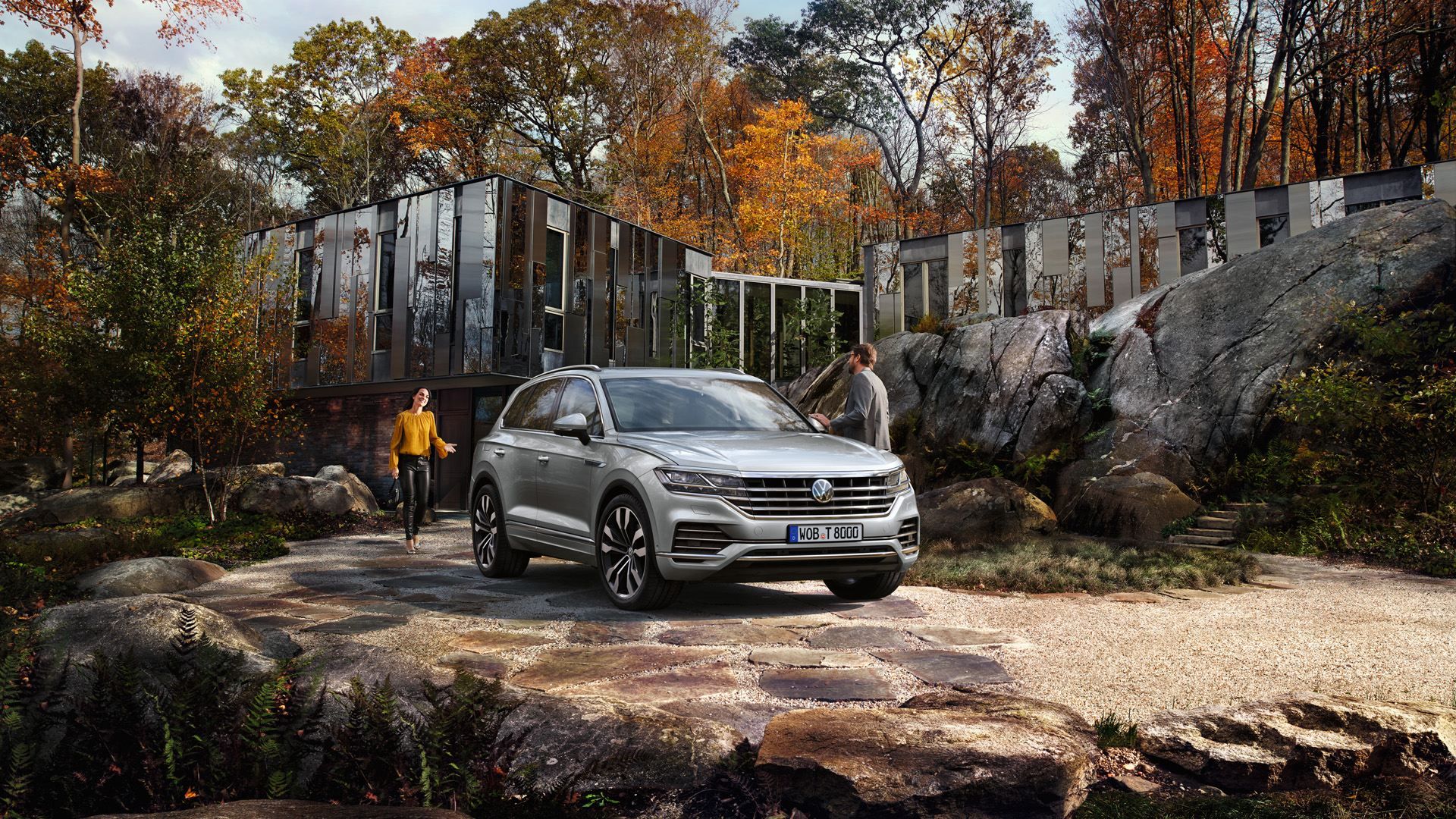 Tg2042 touareg in front of a house with man standing next to drivers side and woman approaching 16 9 f cc2